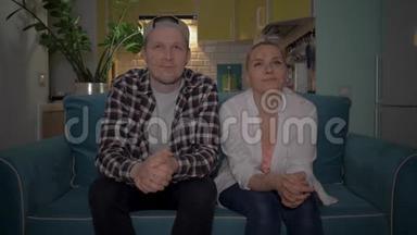 一个男人和一个女孩坐在厨房背景下的沙发上看<strong>电视</strong>。 4K