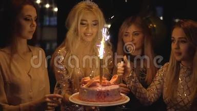 在一个黑暗的房间里和朋友一起参加生日聚会时，用烟火做蛋糕。 25岁生日或女孩。