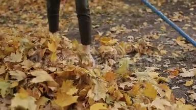 女孩准备用<strong>耙子</strong>清理秋天的树叶。 一个女人拿着<strong>耙子</strong>。 特写