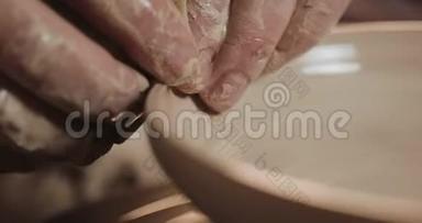 波特在陶工`的车轮使用他的手和陶器工具制作陶瓷产品。 快关门。 手工制作，工艺.. 白色
