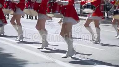 在城市街道上，穿着红色服装的鼓手女孩们的节日游行的<strong>街头表演</strong>。慢动作