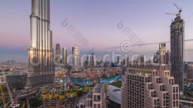 日落后迪拜市区的全景式天际线景观，<strong>商场</strong>、喷泉和摩天大楼在白天到夜间空<strong>中</strong>盘旋