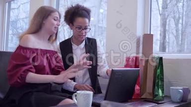 <strong>网上</strong>购物，快乐的非裔美国女孩与朋友使用现代技术支付<strong>网上</strong>购物坐着
