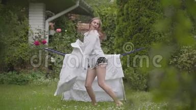 漂亮开朗的年轻女人在后院唱歌跳舞很有趣，同时做家务和亚麻布。 洗衣日