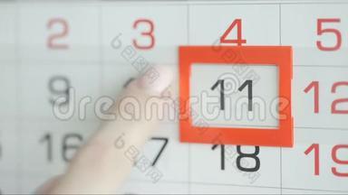 女人`在墙上的日历上交办公室更改日期。 变动10至11