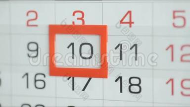 女人`在墙上的日历上交办公室更改日期。 变动9至10