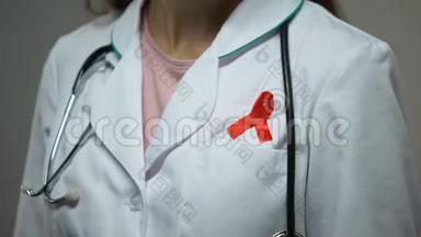 女医生在医疗服上贴上红丝带，开展<strong>艾滋病宣传</strong>运动