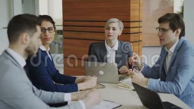 女商人听同事在现代办公室的餐桌旁<strong>讲解</strong>商业项目