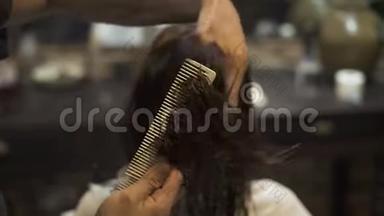 美发师在美容工作室用理发剪梳理湿发。发型师用剪刀和梳子
