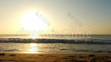 海滩上灿烂的金色夕阳，沙滩上的浪花，贝壳.. 海洋，清澈。 金色的阳光反射在海滩上。 孙世宁