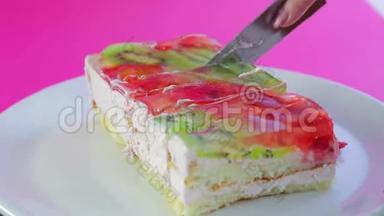 女人手拿刀把水果蛋糕切成块