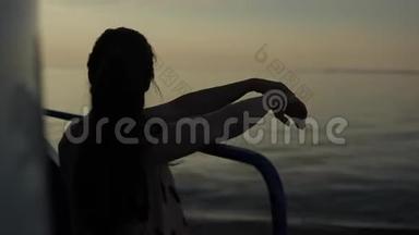 一个美丽的女孩站在一艘客船的甲板上，她的手臂放在扶手上，欣赏着河的景色。