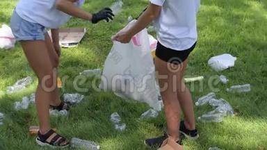 志愿者清理园区垃圾.. 人们在草地上捡一瓶塑料