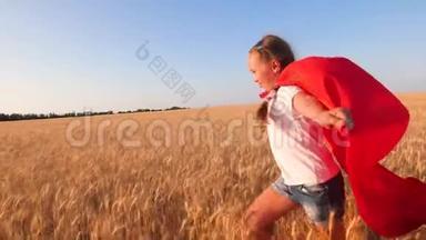 穿红色斗篷的年轻女孩扮演超级英雄，在蓝天下带着小麦跑过田野。