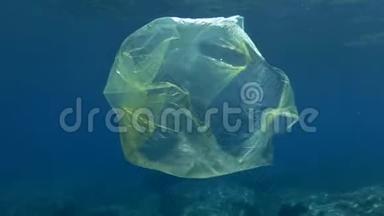 塑料污染，蓝色水中黄色塑料袋。 慢动作丢弃的塑料袋在水面下慢慢漂流