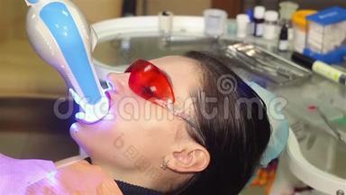 年轻女子在牙科医生办公室用紫外线`机器进行紫外线<strong>美白</strong>.