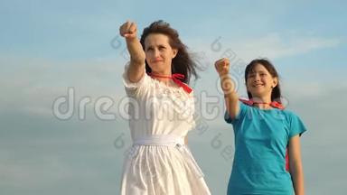妈妈和女儿穿着红色<strong>斗篷</strong>扮演超级英雄。 幸福的家庭扮演超级英雄。 妈妈和孩子穿上红色的<strong>斗篷</strong>