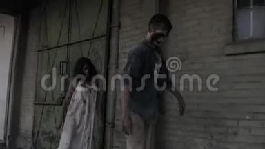 两个僵尸正在走，背景上有一座废弃的房子。 布吕内特女孩，脸受伤，浑身是血