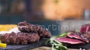 切片烤肉放在黑摊上.. 为汉堡烤肉。 绿色薄荷叶。 调味品。 一切都在桌子上。 这就是