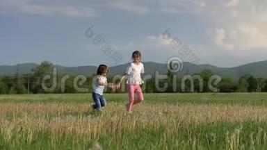 美丽的风景两个欢快的小妹妹跑在蒲公英的田野里，笑着享受童年。 自由和h概念