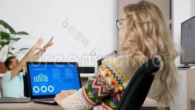 女人看着客厅电脑上的动画财务图表