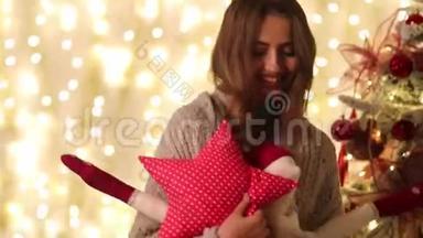 带着格子的年轻女人和圣诞老人手里拿着一个星星形状的枕头，走在圣诞树旁边。