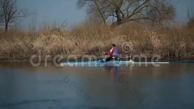 用独木舟追踪残疾人运动员在河上划船的镜头。 划艇，划艇，划艇.. 培训。 皮划艇