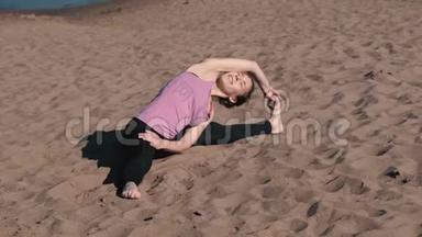 女人在城市的海滩上伸展瑜伽。 瑟萨萨纳，苏普塔·普塔维斯塔·科纳萨纳的姿势。