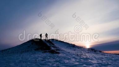 <strong>登山</strong>者，两个背着背包的旅行者的剪影向对方展示了冬季<strong>登山</strong>时的相机