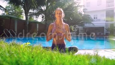 瑜伽姿势的女孩放松，双手放在泳池的胸部