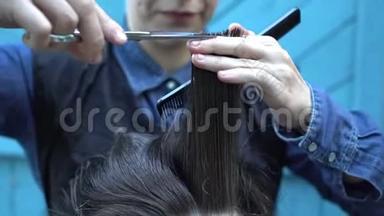在夏季的户外理发店里，年轻的女理发师慢慢地梳理和有趣的男人的头发