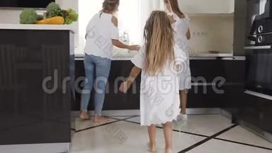后视图一个头发很轻的女孩在<strong>妈妈</strong>和妹妹的<strong>怀里</strong>跑在房间里。 一间轻型客房