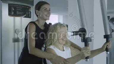老年妇女与私人教练在<strong>健身房</strong>的模拟器上订婚。 女儿在<strong>健身房</strong>帮妈妈