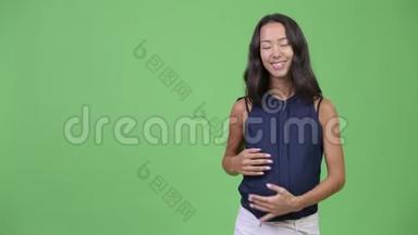 年轻快乐怀孕的多民族女商人展示了