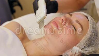 美容师让一个年轻女孩在水疗中心对面部进行超声波清洗。