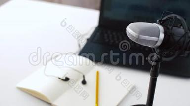 桌上笔记本上的麦克风、笔记本电脑和耳机
