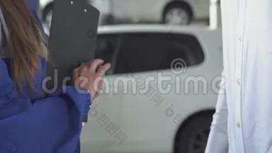 女汽车专家在拍了有关汽车的数据后，签了名，拿起钥匙和握手