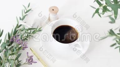 电影院。 咖啡杯，婚礼花束，<strong>绸带</strong>和白色桌子背景上的金笔。 桉树枝