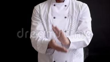穿西装的成年男厨师从面粉中敲开他的手。 面粉颗粒的缓慢运动