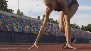 自信的女人准备在体育场的<strong>起跑线</strong>上奔跑，慢动作