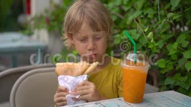 一个小男孩在街头市场吃美味的煎饼的特写镜头。 街头食品概念