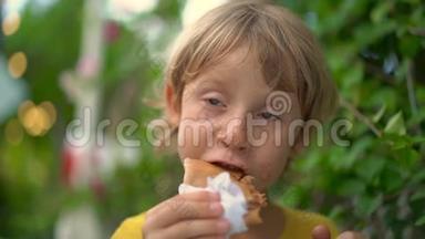 一个小男孩在<strong>街头</strong>市场吃美味的煎饼的特写镜头。 <strong>街头</strong>美食概念。