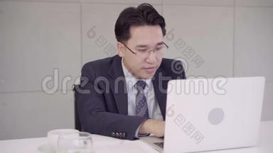 慢动作-成功的亚洲首席执行官商人穿着西装，在<strong>办公</strong>室工作场所的<strong>办公</strong>桌上<strong>用笔</strong>记本电脑工作。