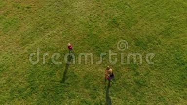 一位年轻女子和她的小儿子在公园里玩塑料飞机的俯视镜头