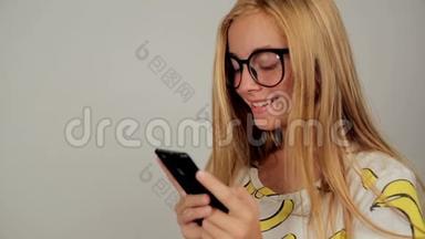 可爱的年轻女子在<strong>录音</strong>室戴着眼镜在手机上发短信