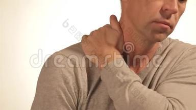 男人按摩他疼痛的肩膀，试图减轻疼痛的白色背景。 健康问题
