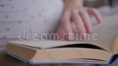 女人在书中翻页。 女人读了一本书。