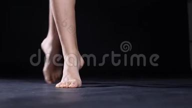 赤脚芭蕾，芭蕾舞演员优雅地旋转在一个<strong>舞蹈工作室</strong>孤立的黑色背景。 4k