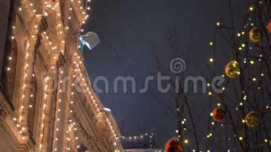 在大雪纷飞的节日夜晚，装饰着花环和球在树上的房子