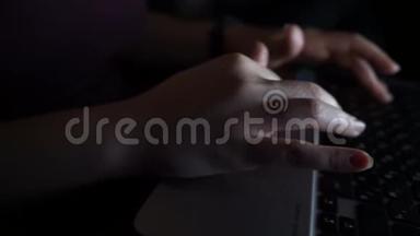 女人在黑暗的夜晚用笔记本电脑打字。 手在关键字与电脑上面打字.. 晚期网瘾或工作